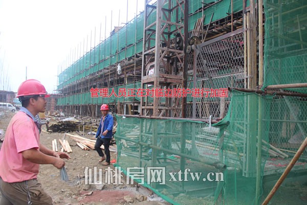 B1区西侧管理人员正在对临边防护进行加固